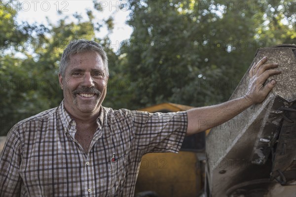 Caucasian man leaning on tractor