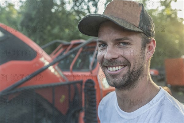 Caucasian man posing near tractor