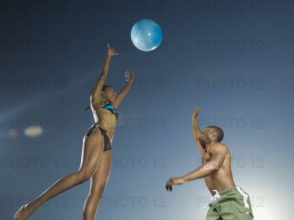 African American couple playing with beach ball