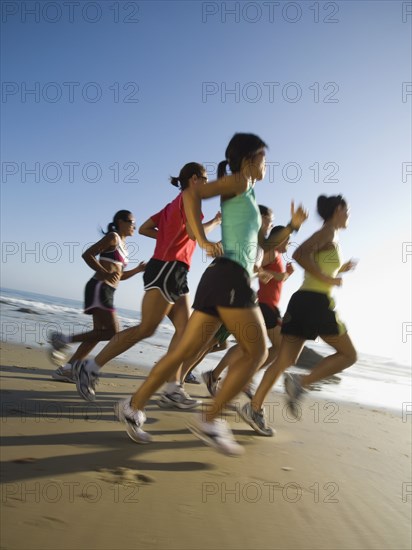 Multi-ethnic runners racing at beach