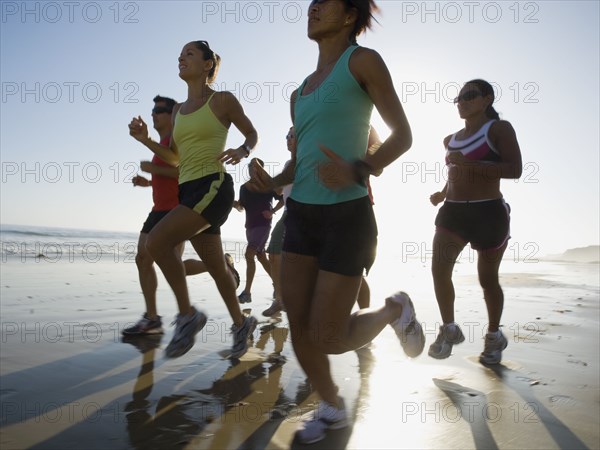 Multi-ethnic runners racing at beach