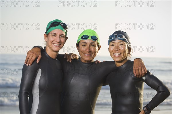 Multi-ethnic women wearing wetsuits and goggles