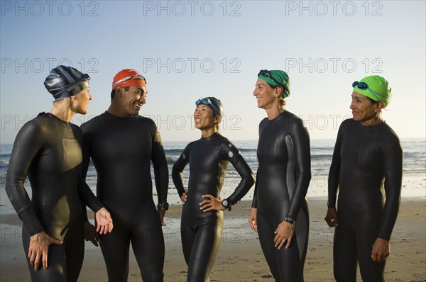 Multi-ethnic swimmers wearing wetsuits and goggles