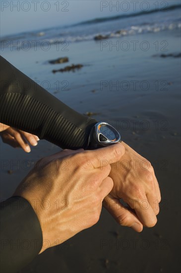 Hispanic male swimmer checking watch