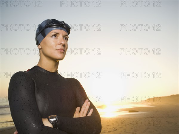 Hispanic woman wearing wetsuit and goggles