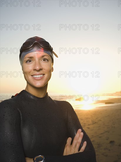 Hispanic woman wearing wetsuit and goggles