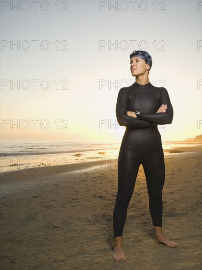 Hispanic woman wearing wetsuit and goggles