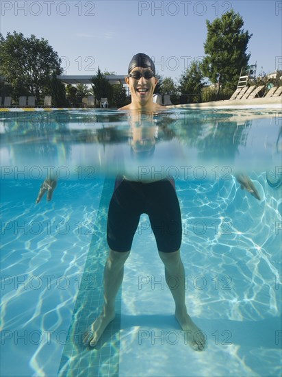 Asian man standing in swimming pool