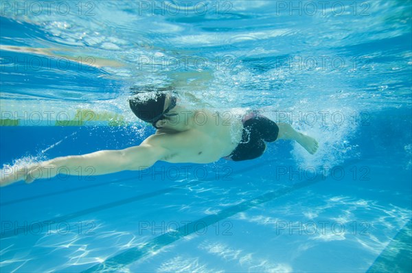 Underwater shot of Asian man swimming