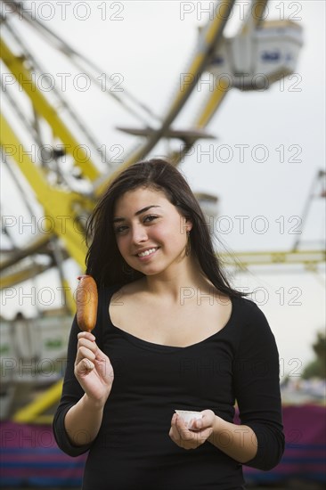 Mixed Race girl holding corn dog