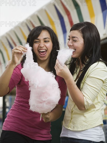 Multi-ethnic teenaged girls eating cotton candy