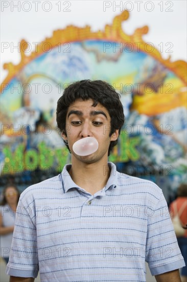 Mixed Race teenaged boy blowing bubble gum bubble