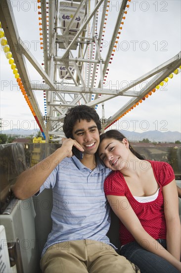 Multi-ethnic teenaged couple on carnival ride