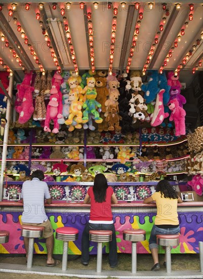 Multi-ethnic teenaged friends playing carnival game