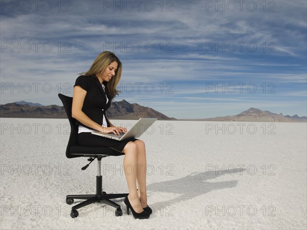 Hispanic businesswoman typing on laptop