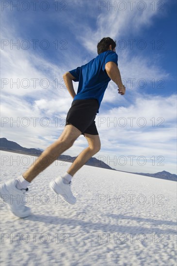 Hispanic man jogging on salt flats