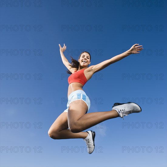 Native American woman jumping in mid-air