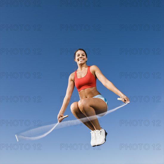 Native American woman jumping rope in mid-air