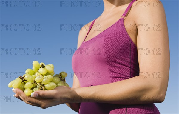 Native American holding a bunch of grapes