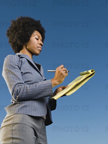 African businesswoman writing on legal pad