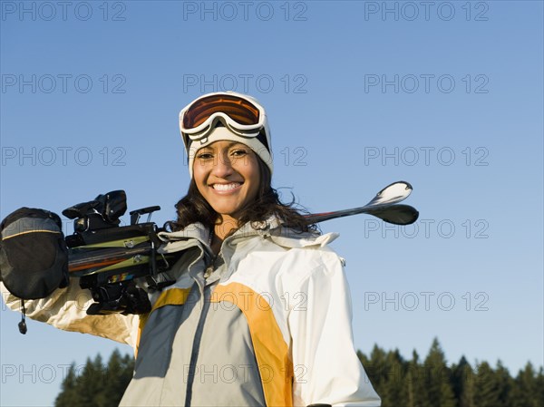 Mixed race woman holding skis