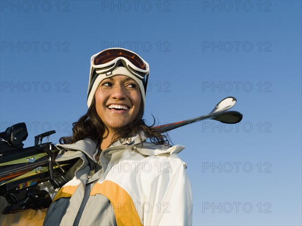 Mixed race woman holding skis