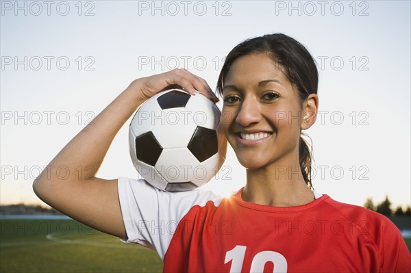 Mixed race woman posing with soccer ball