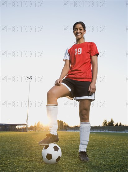 Mixed race woman posing with soccer ball