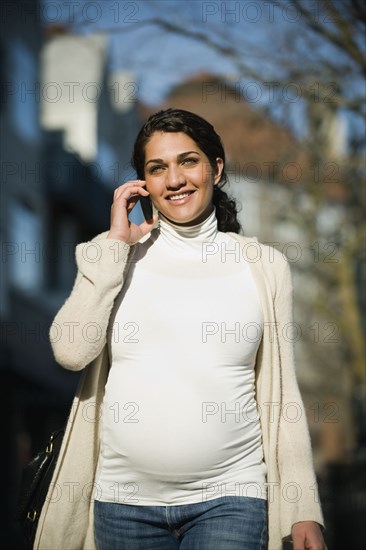 Pregnant Middle Eastern woman talking on cell phone