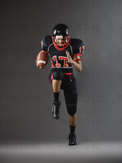 Mixed race football player running with football