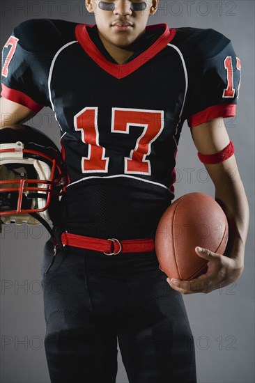 Mixed race football player holding football