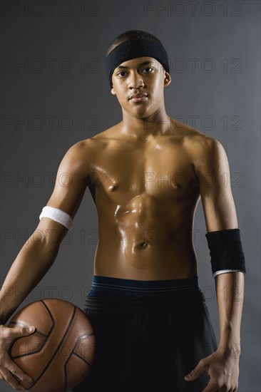 Mixed race basketball player holding ball