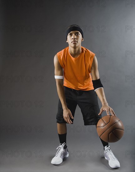 Mixed race basketball player dribbling basketball