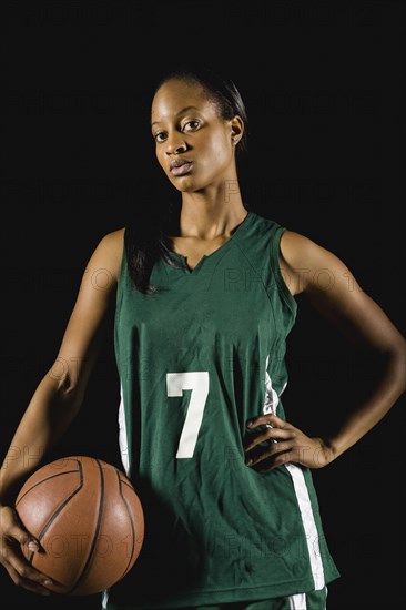 Mixed race basketball player holding basketball