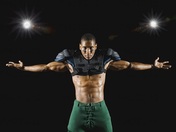 African football player wearing protective pads with arms outstretched