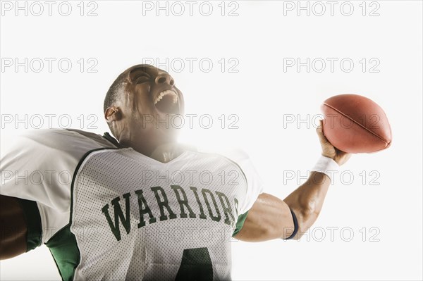 African football player holding football and celebrating