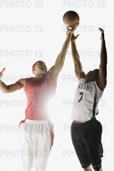 African men jumping for basketball