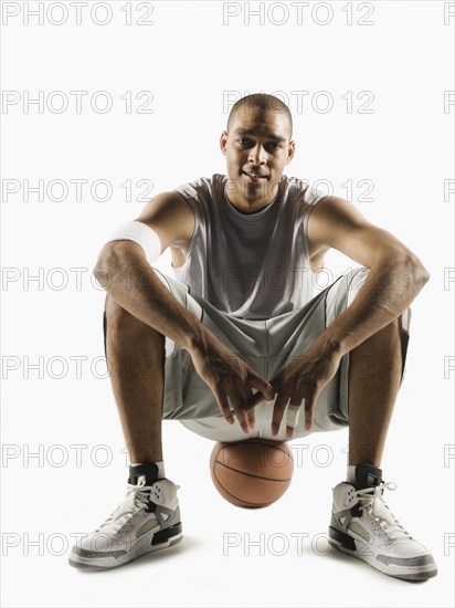 African man sitting on basketball