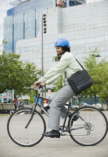 Mixed race man riding bicycle in city