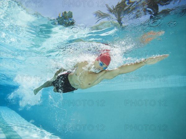 Mixed race man swimming in swimming pool