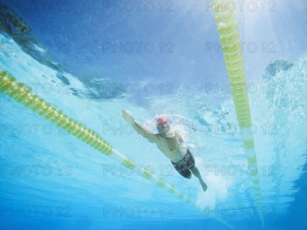 Mixed race man swimming in swimming pool