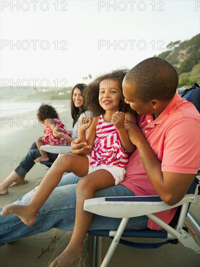 Family sitting together on beach