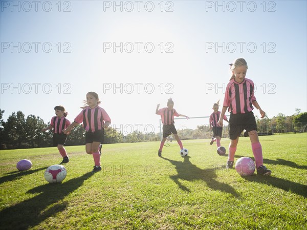 Girl soccer players practicing with soccer balls