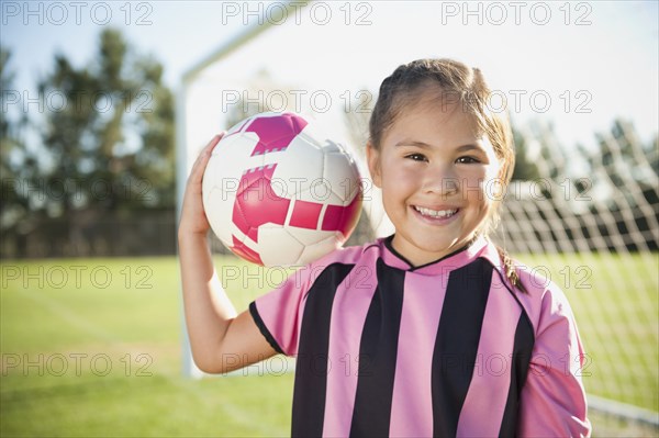 Hispanic girl soccer player holding soccer ball