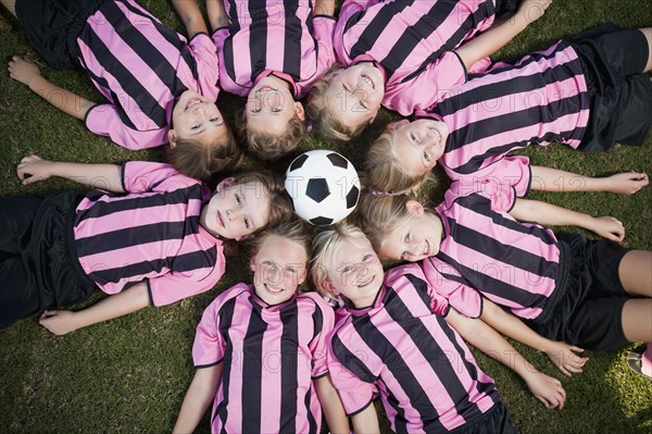 Girl soccer players laying in circle