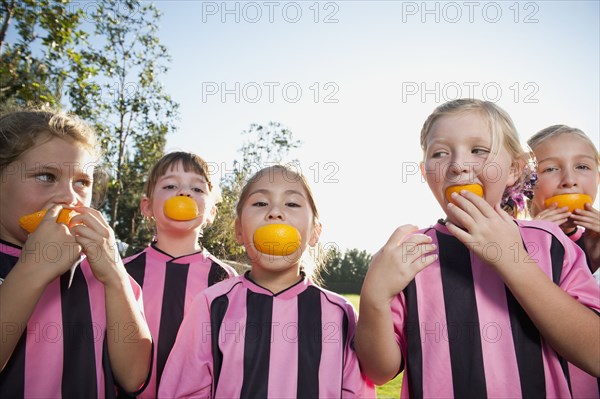 Girl soccer players eating orange slices