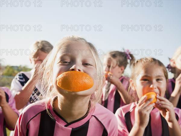 Girl soccer players eating orange slices