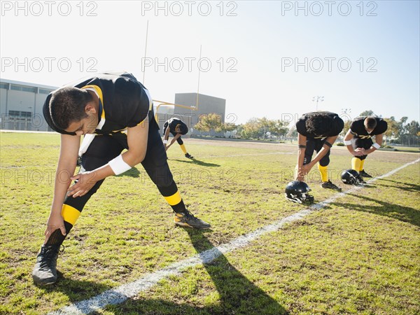 Football players stretching on football field