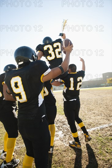 Football players celebrating on football field