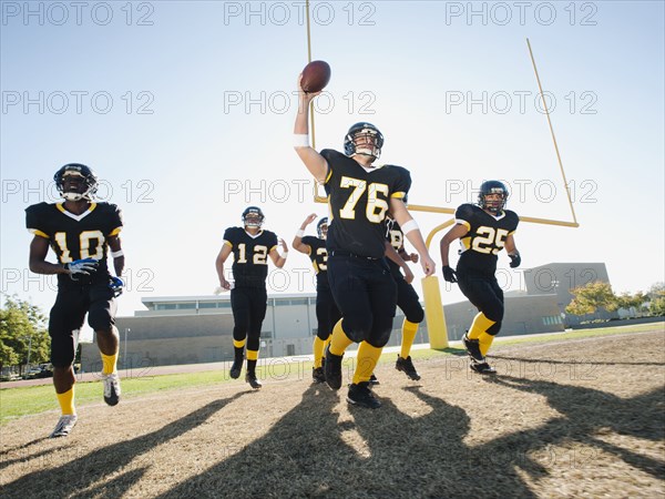 Football players celebrating on football field